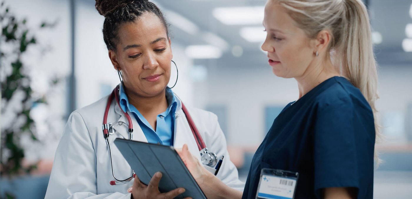 Two women health workers talking to each other and looking at paperwork