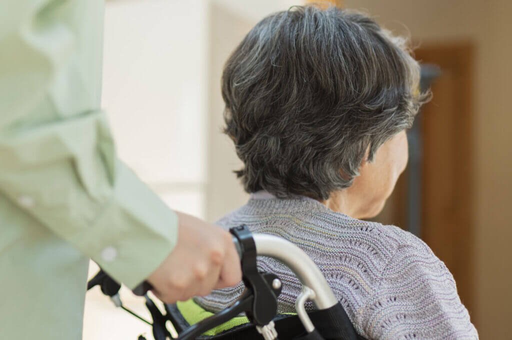 Elderly lady being pushed in a wheelchair