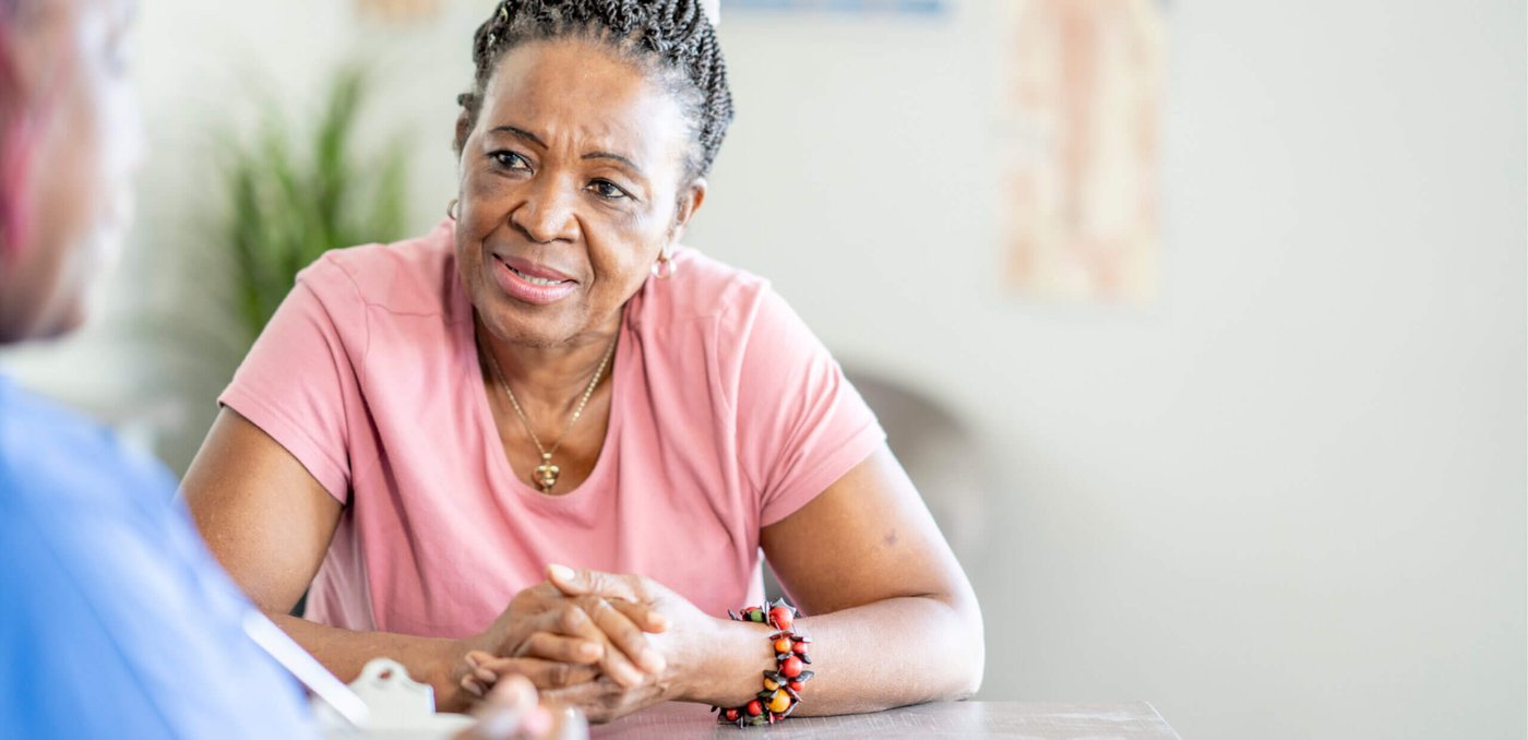 Woman talking to a health care worker at a table